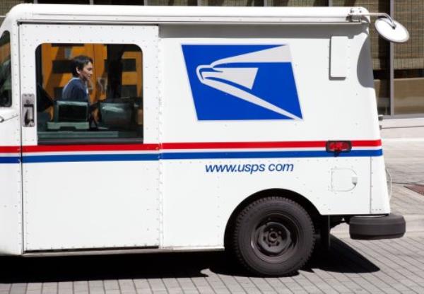 This image shows a USPS mail truck parked on the street near the Bellevue Square Mall in Washington State. You can see the mail delivery man standing on the far side of the truck.