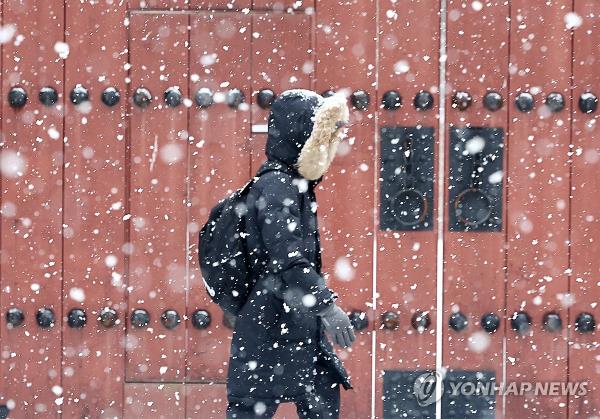 A person walks along a street near Deoksu Palace in central Seoul on Dec. 30, 2023. The state weather agency issued a heavy snow advisory for parts of the capital and surrounding areas earlier in the day. (Yonhap)
