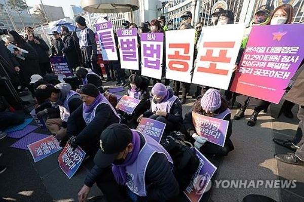 Family members of the victims of the Itaewon crowd crush in 2022 call for President Yoon Suk Yeol to promulgate a special law to reinvestigate the accident in front of the presidential office in Seoul on Jan. 30, 2024, in anticipation of a potential presidential veto against it. (Yonhap)