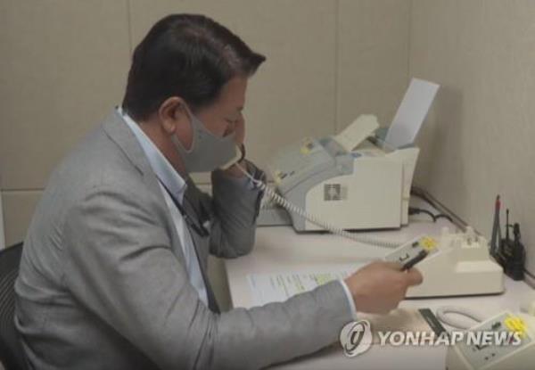 This file photo, provided by the unification ministry, shows a South Korean liaison officer talking to his North Korean counterpart at the Seoul bureau of their joint liaison office on Oct. 4, 2020. (PHOTO NOT FOR SALE) (Yonhap)