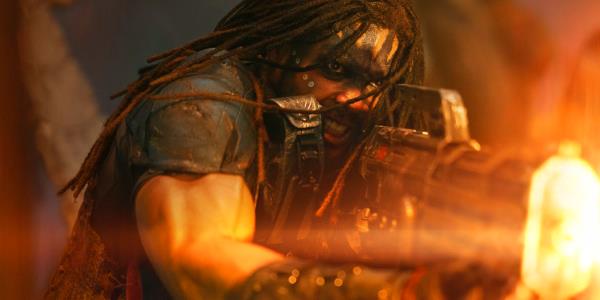 Ray Fisher as Darrian Bloodaxe in Rebel Moon firing a large gun