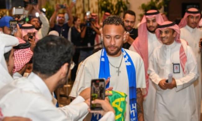 Neymar greets fans as he arrives at the airport in Riyadh, Saudi Arabia.