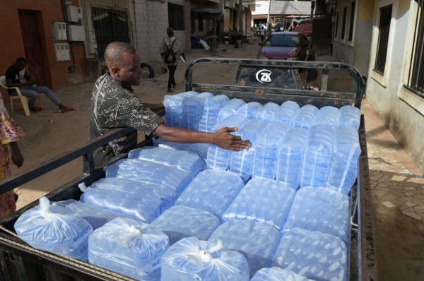 A man loads plastic sachets filled with drinkable water for delivery.